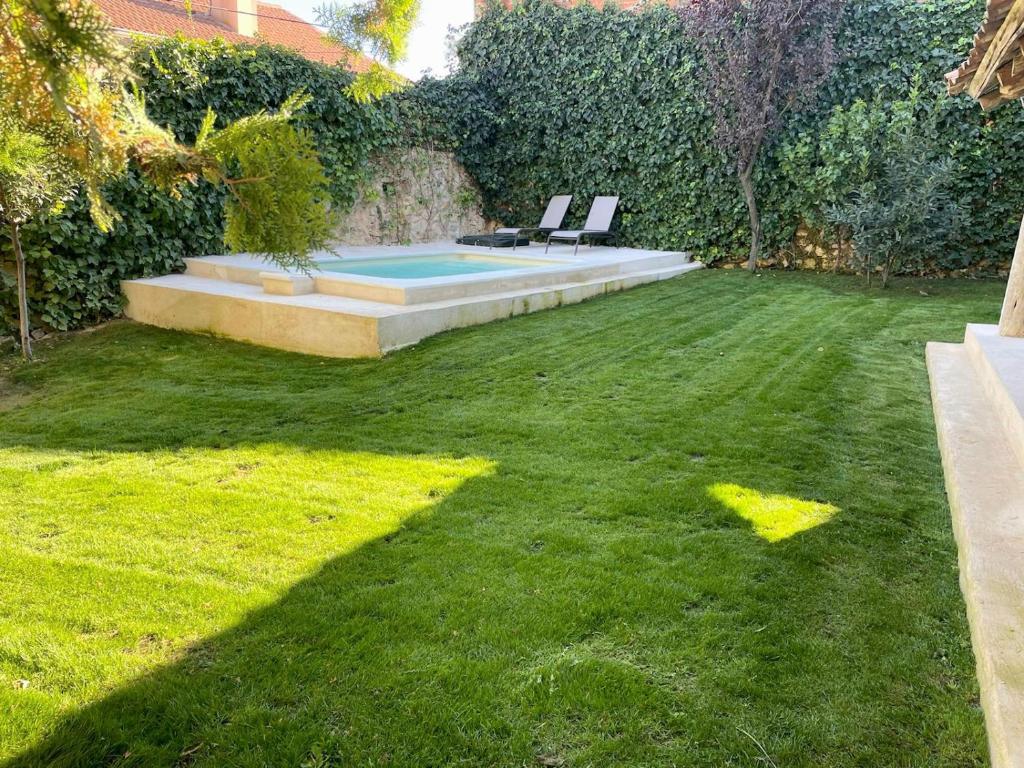 un cortile con una piscina e due sedie sull'erba di Casa de las Eras a Valdesimonte