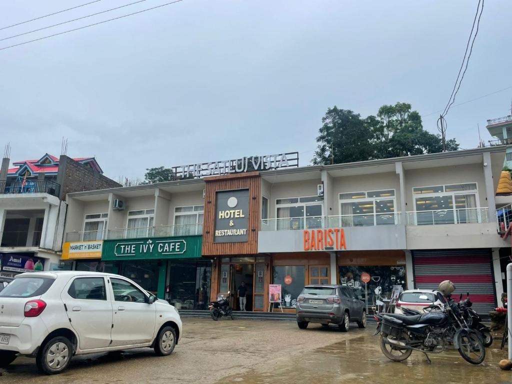 a street with cars parked in front of a building at The Satluj Vista in Bilāspur