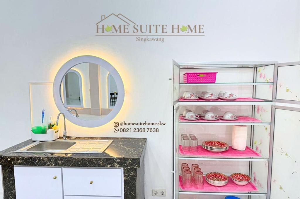 a bathroom with a sink and a shelf with pink items at Home Suite Home Singkawang in Singkawang