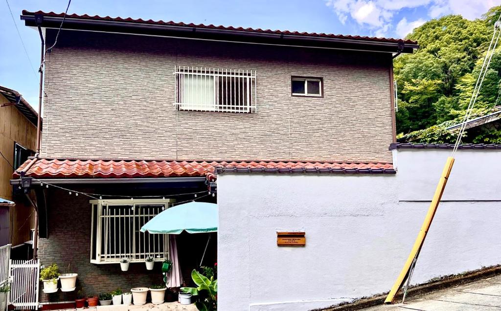 una casa con una puerta blanca y una sombrilla en Grace House Hill Paradise Atami, en Atami