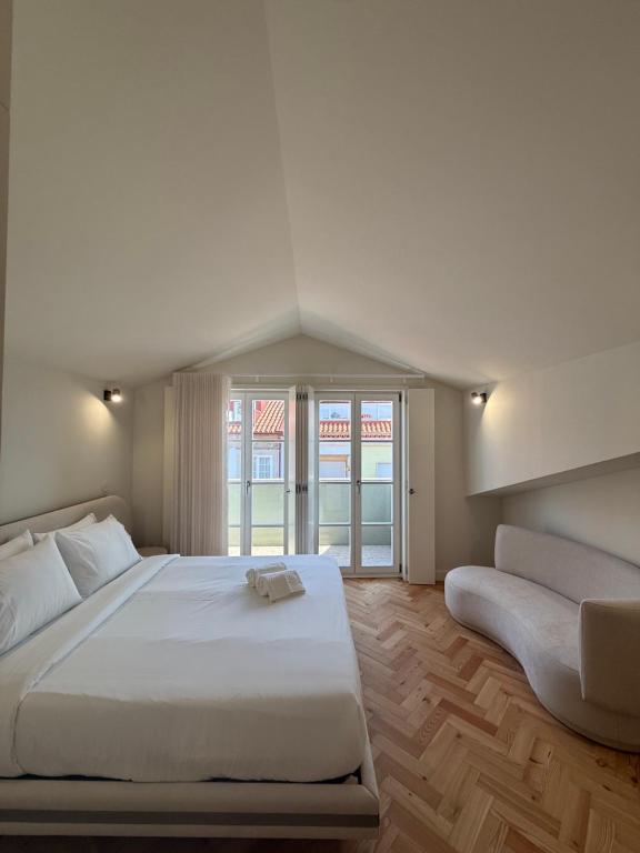 a bedroom with a large white bed and a couch at Luxury Duplex Apartment with terrace by Perpetual Relax in Braga
