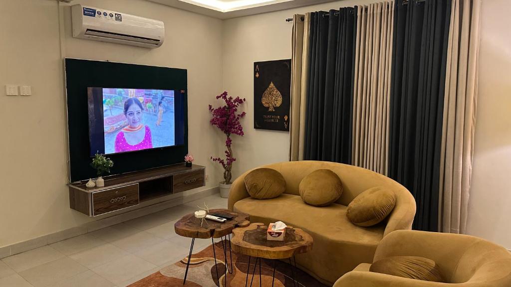 a living room with a couch and a television at Luxury 1BHK Apartment with Eiffel View Bahria in Lahore