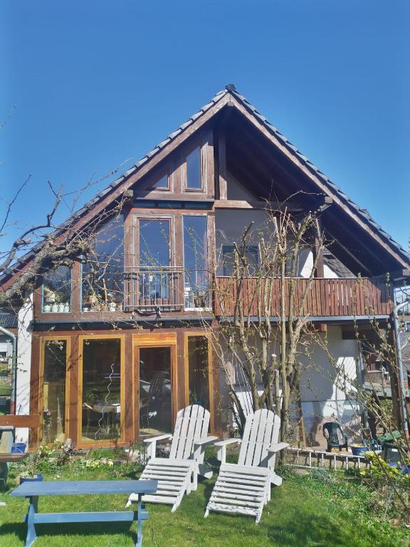 a couple of chairs sitting in front of a house at Ferienwohnung Eichfeld in Malsfeld