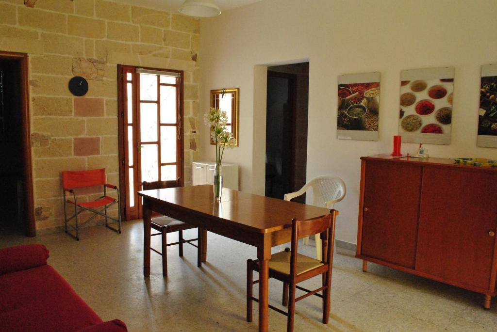 sala de estar con mesa de madera y sillas en Residenza del Sole Mare, en Torre Rinalda