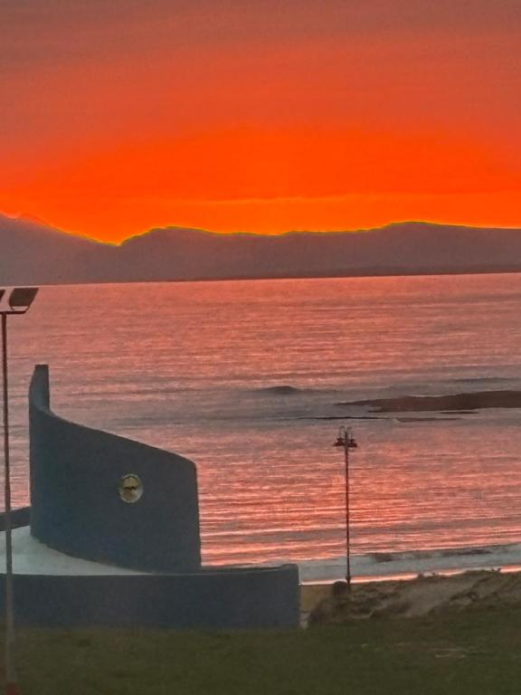 a painting of a sunset over the ocean at Central stunning sea view 2 bedroom apartment in Bundoran