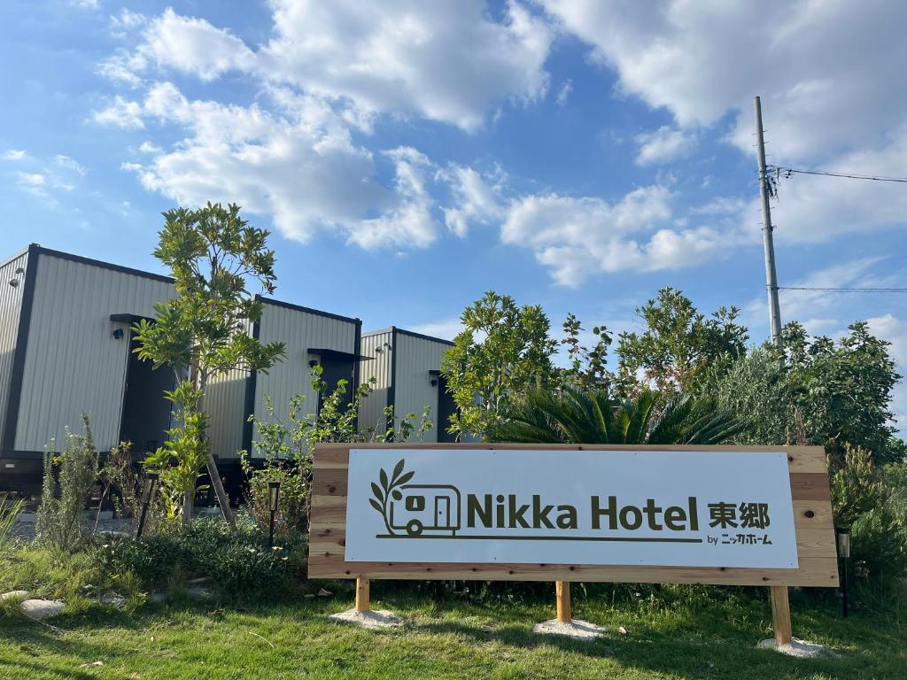 Un cartel de un hotel Nikka frente a un edificio. en NikkaHotel東郷店, en Togo