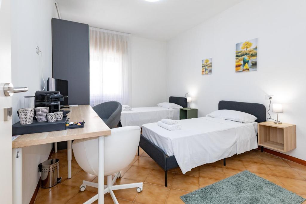Zimmer mit 2 Betten und einem Schreibtisch mit einem Computer in der Unterkunft Ampia stanza moderna Venezia a 10 minuti in Venedig