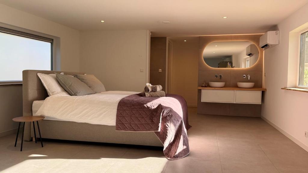 a bedroom with a large bed and a mirror at B&B Ztrand in Oudesluis