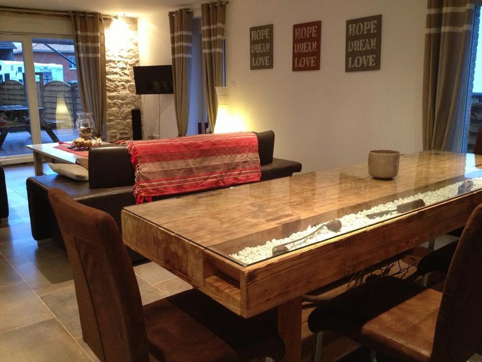 a living room with a table and a couch at la menuiserie in Jeuxey
