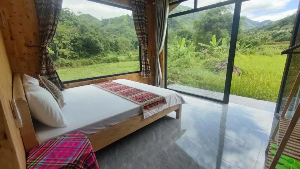 a bedroom with a bed and a large window at Du già Mit's homestay in Yên Minh
