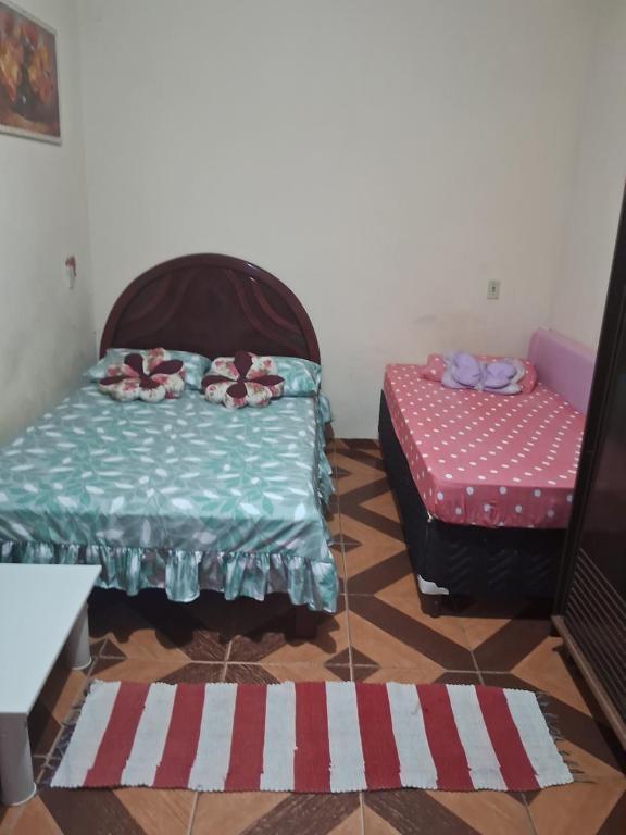 a room with two beds and a table at Recanto feliz in São Thomé das Letras