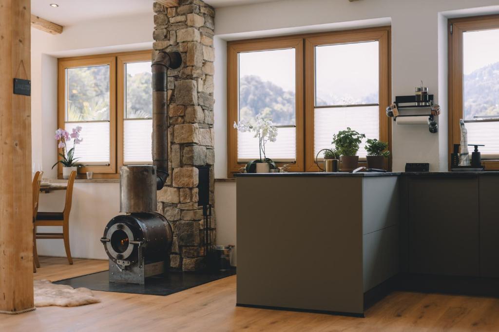 a kitchen with a stove in a room with windows at Lodge 2713, Privat Spa ,Sauna, Outdoor Whirlpool, Kamin, Kfz Ladestation, Top Alpenpanorama, in Bischofswiesen