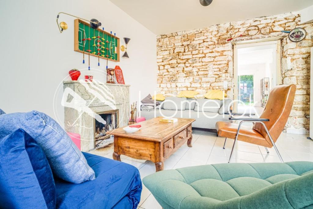 ein Wohnzimmer mit einem Kamin und einem blauen Sofa in der Unterkunft Maison spacieuse cœur de ville avec spa & cheminée in Lorient