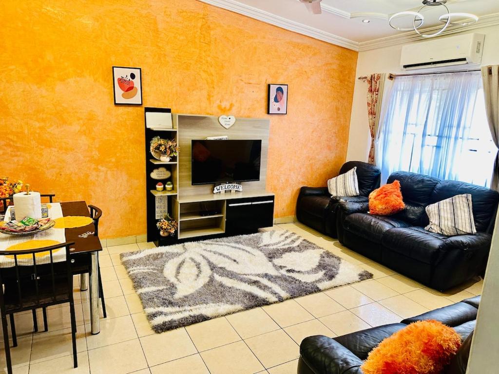 Una sala de estar con un sofá y un televisor. en Monimelia, en Ashalebotwe