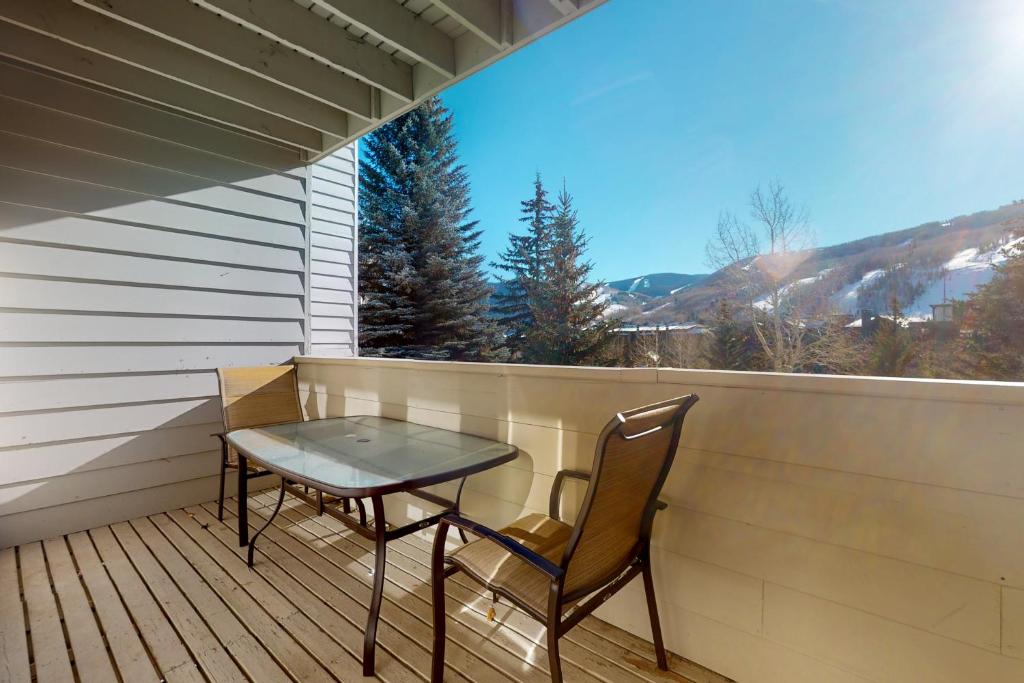 a table and chairs on a balcony with a view at Sun Vail 24B in Vail