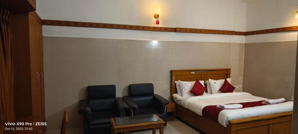 une chambre d'hôtel avec deux lits et une chaise dans l'établissement Skyry Hotels Gandhipuram, à Coimbatore
