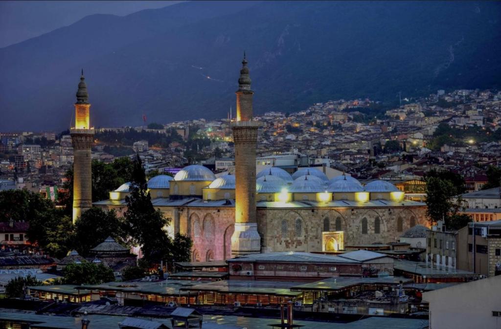 a large building with two towers and a city at night at Ozan suit in Bursa