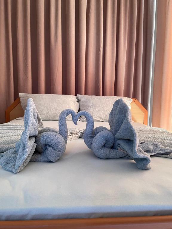 two blue stuffed elephants laying on a bed at Хостел-Lotus in Veliki Preslav