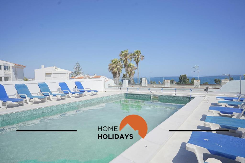 una piscina con sedie a sdraio blu e la scritta "casa vacanze" di #285 Vista do Mar By Home Holidays a Páteo