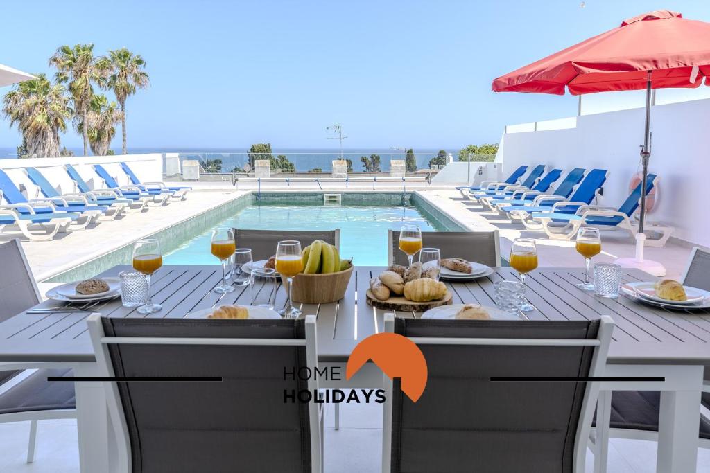 a table with food and drinks next to a swimming pool at #285 Vista do Mar By Home Holidays in Páteo