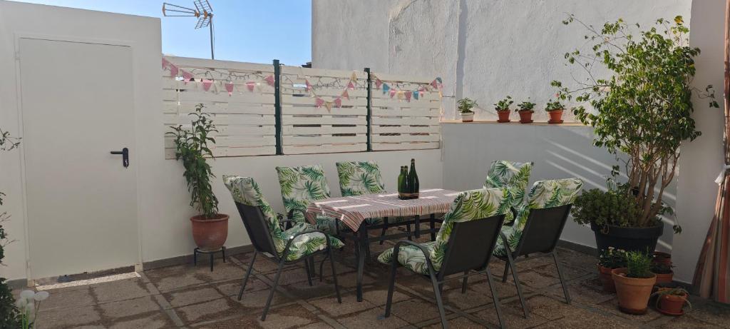 ein Tisch und Stühle auf einer Terrasse mit Pflanzen in der Unterkunft La Casa de Antonina in Castilblanco de los Arroyos