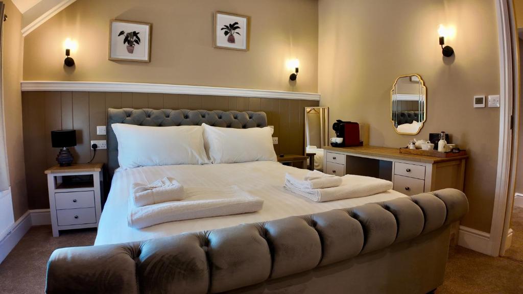 a bedroom with a large bed with towels on it at Bronn Ewhella - Rising Sun Inn in Altarnun