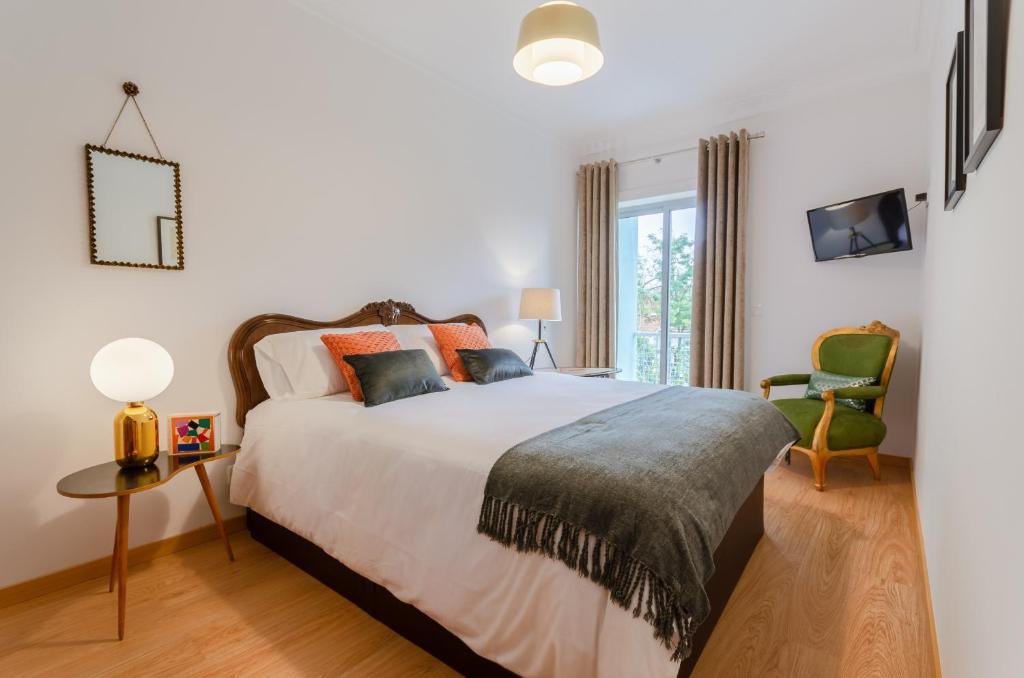 a bedroom with a large bed and a chair at Setubal Boutique Apartment I by Homing in Setubal