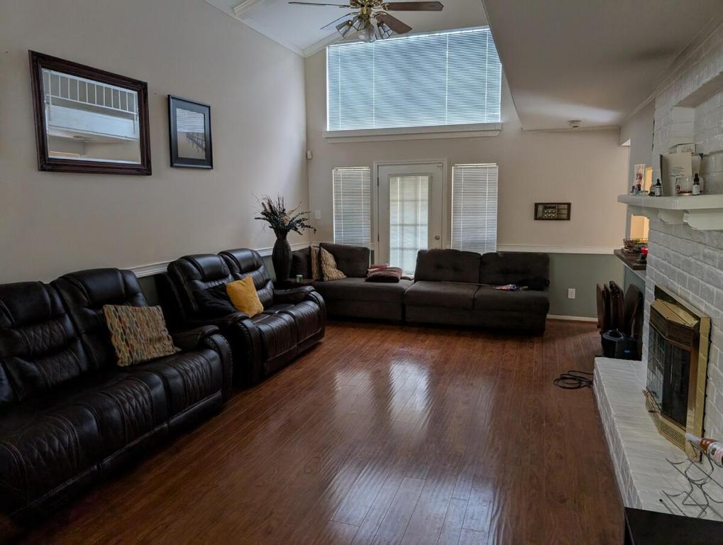 a living room with black leather furniture and a fireplace at Cozy Townhome in Missouri City