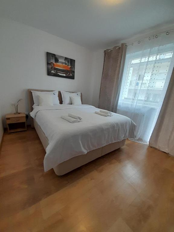 a bedroom with a large white bed and a window at Alina Sweet Home in Sibiu