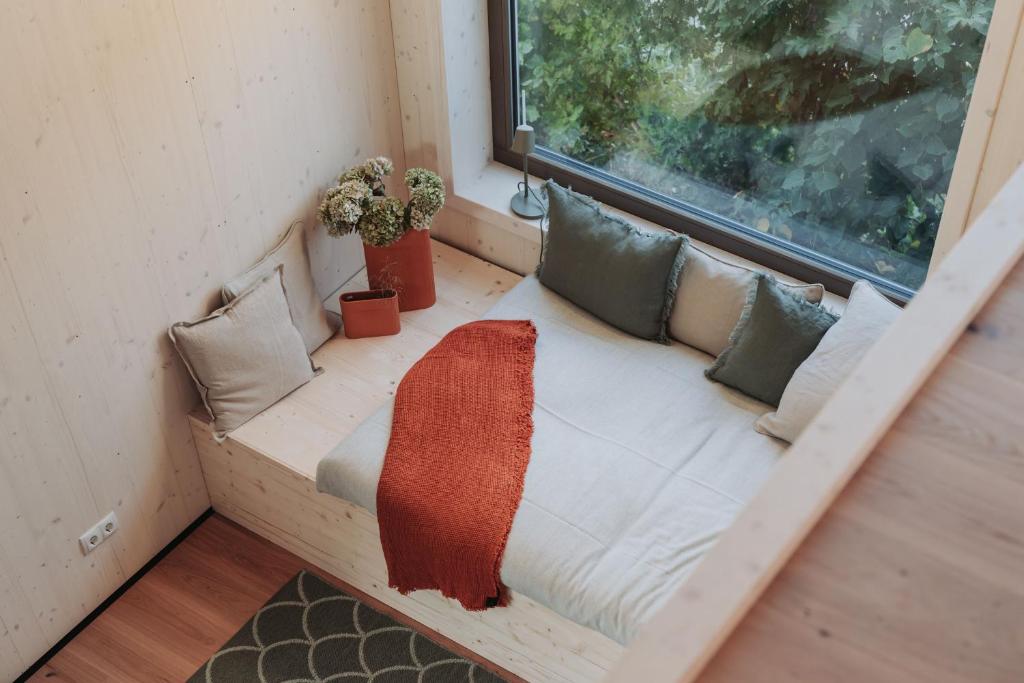 un sofá en una habitación con ventana en Die Tinys - Tiny Häuser am Attersee, en Nussdorf am Attersee