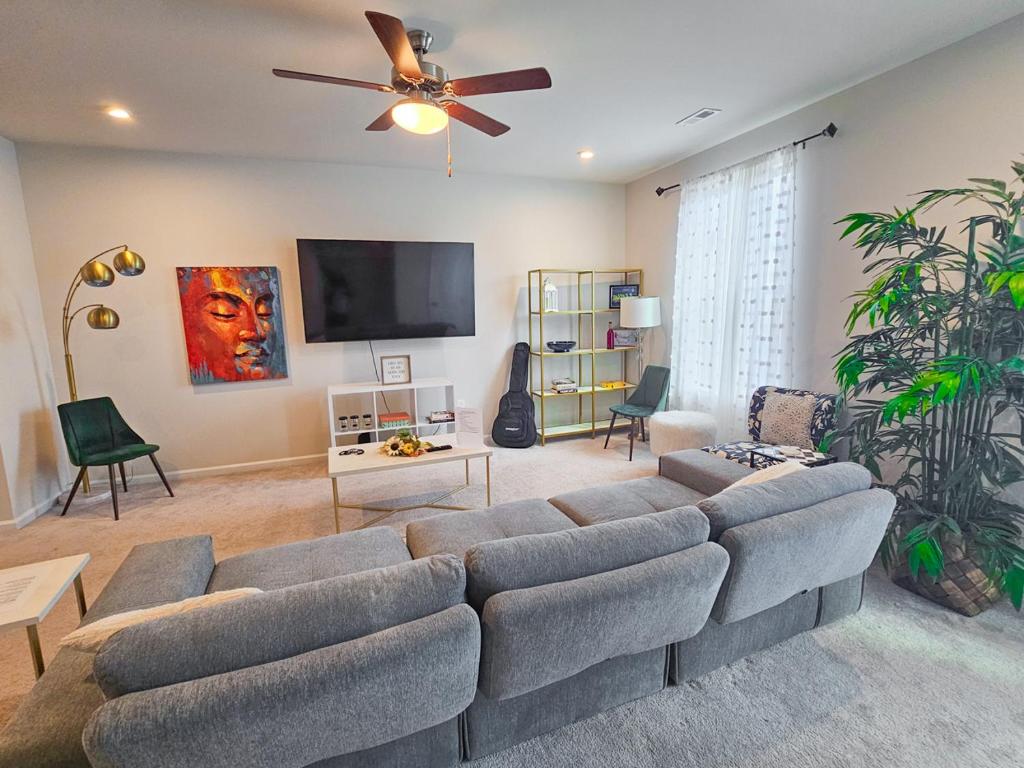 a living room with a couch and a flat screen tv at Impeccable 3BR Townhouse Near RDU & Hospitals in Cary