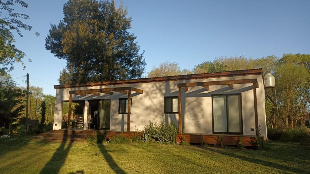 a small house with a large yard in front of it at Casa Los Sauces in Chascomús