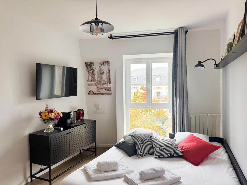 a bedroom with a bed and a tv and a window at Studio Cosy avec parking privé - RER A - proche Paris & Disney in Noisy-le-Grand