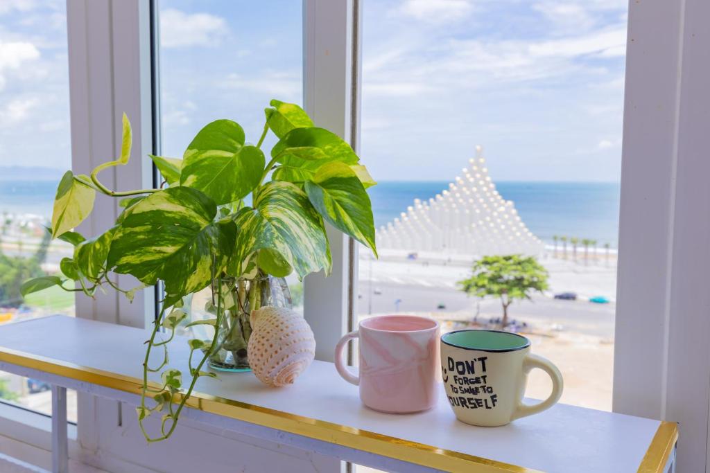 a window sill with two coffee cups and a plant at Căn hộ Oasky 3 Phòng Ngủ 2WC Giá Rẻ Sát Tháp Tam Thắng Bãi Sau Vũng Tàu in Vung Tau