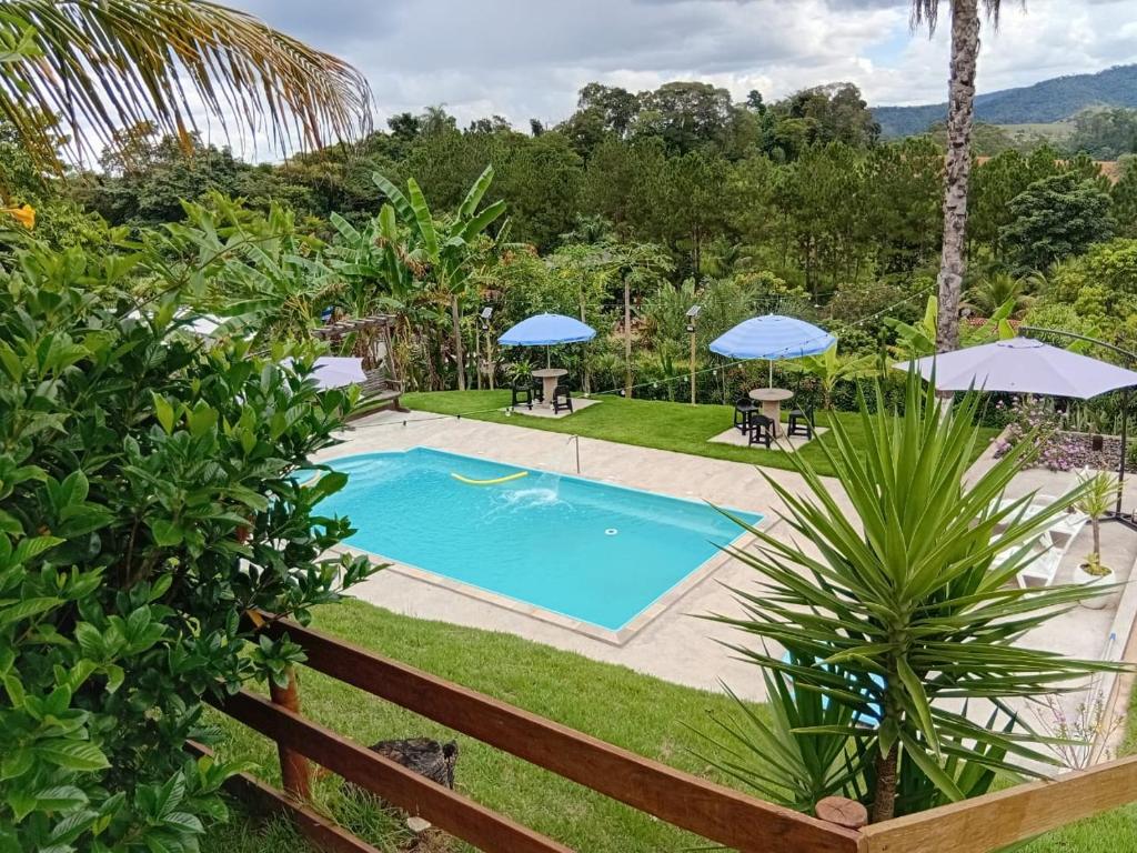 a swimming pool in a yard with umbrellas at Chácara Recanto da família in Jacutinga