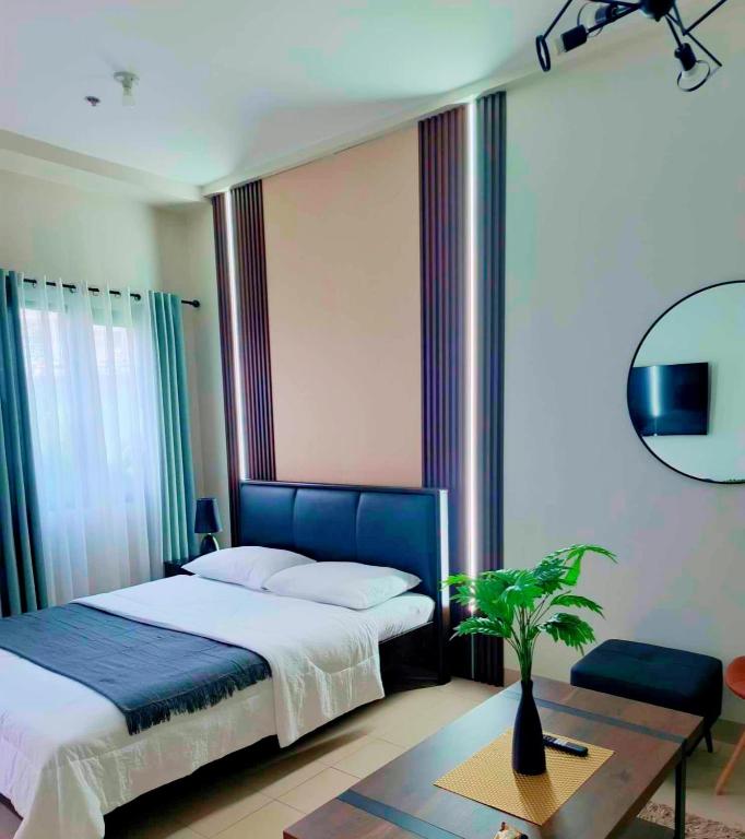 a bedroom with a bed and a table with a plant at Hill Residences by KJA in Manila