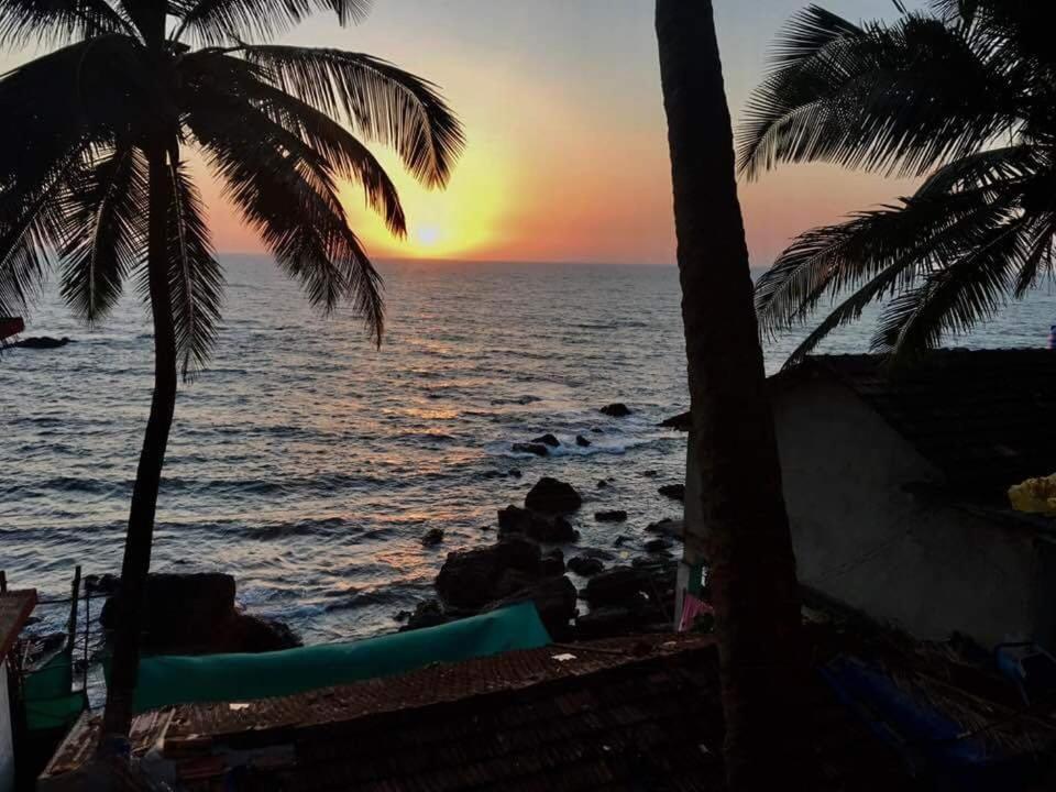 een zonsondergang op het strand met twee palmbomen bij G naik part 2 in Arambol
