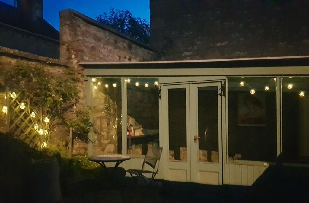 d'une terrasse avec une table, des chaises et des lumières. dans l'établissement Institution Road, à Elgin