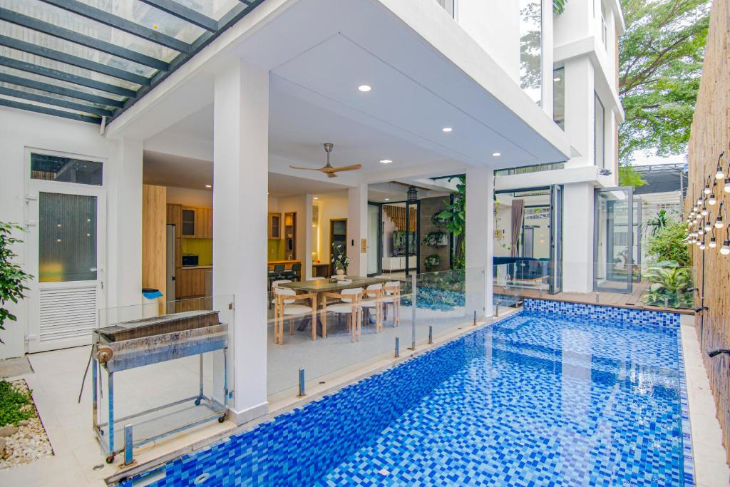 a house with a swimming pool and a dining room at Maison Villa Nature Luxe in Ho Chi Minh City