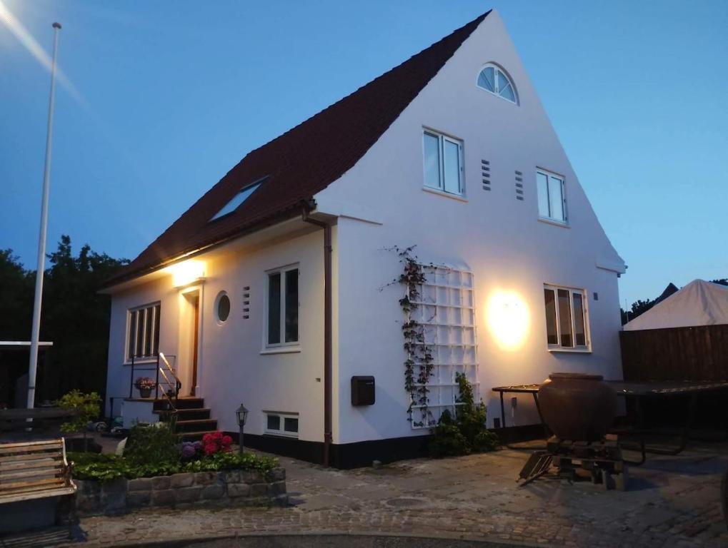 a white house with a black roof with a picnic table at Lovely villa for families and business traveler's in Aalborg
