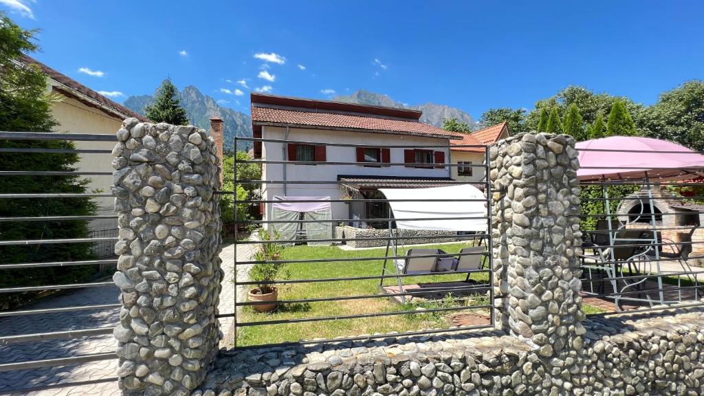 a stone fence in front of a house at Vila Natalie in Buşteni