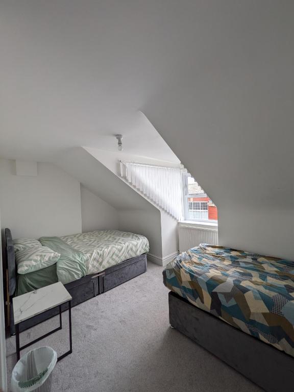a bedroom with two beds and a staircase at Bay Walk Place in Morecambe