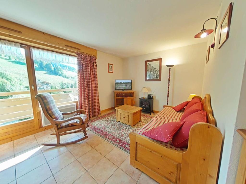a bedroom with a bed and a chair and a window at Appt 3 pièces, 6 couchages, proche commerces et pistes, parking inclus, animaux admis - FR-1-241-177 in Le Grand-Bornand