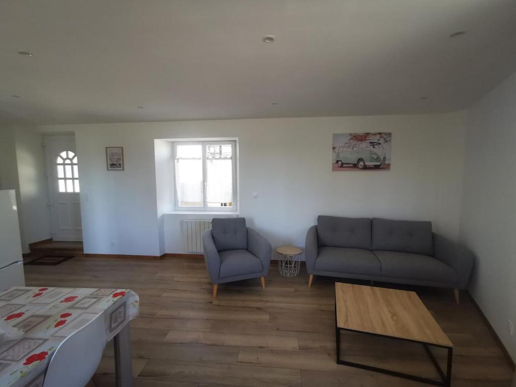 ein Wohnzimmer mit zwei Sofas und einem Tisch in der Unterkunft Appartement au bord de la Vienne in Châtellerault