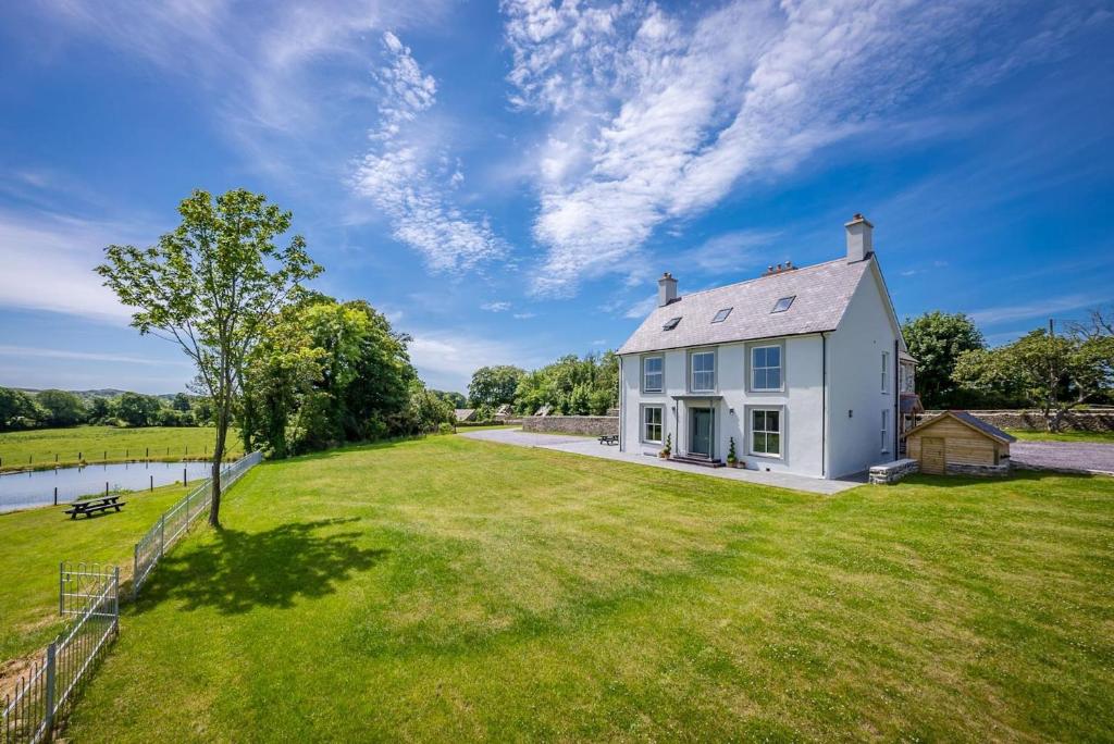 an image of a white house with a yard at Hendre-Feinws in Pwllheli