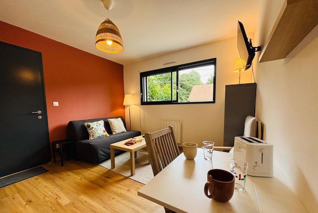 a small living room with a table and a couch at Echappée Bel' cosy studio Baie de Somme in Bellancourt