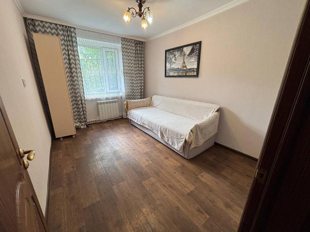 a bedroom with a bed in the corner of a room at Ермекова in Karagandy
