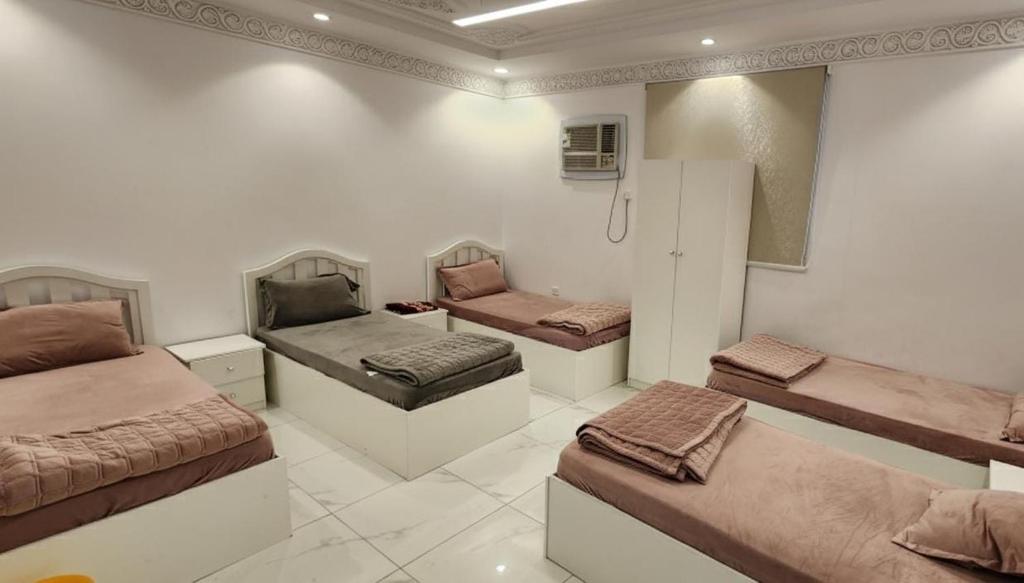 Zimmer mit 3 Betten und einem Kühlschrank in der Unterkunft مرافئ in Medina