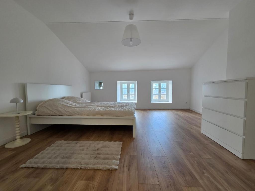 ein weißes Schlafzimmer mit einem Bett und einer Kommode in der Unterkunft Charmante maison de pierre rénovée a 5min de Charleville-Mézières in Saint-Marceau