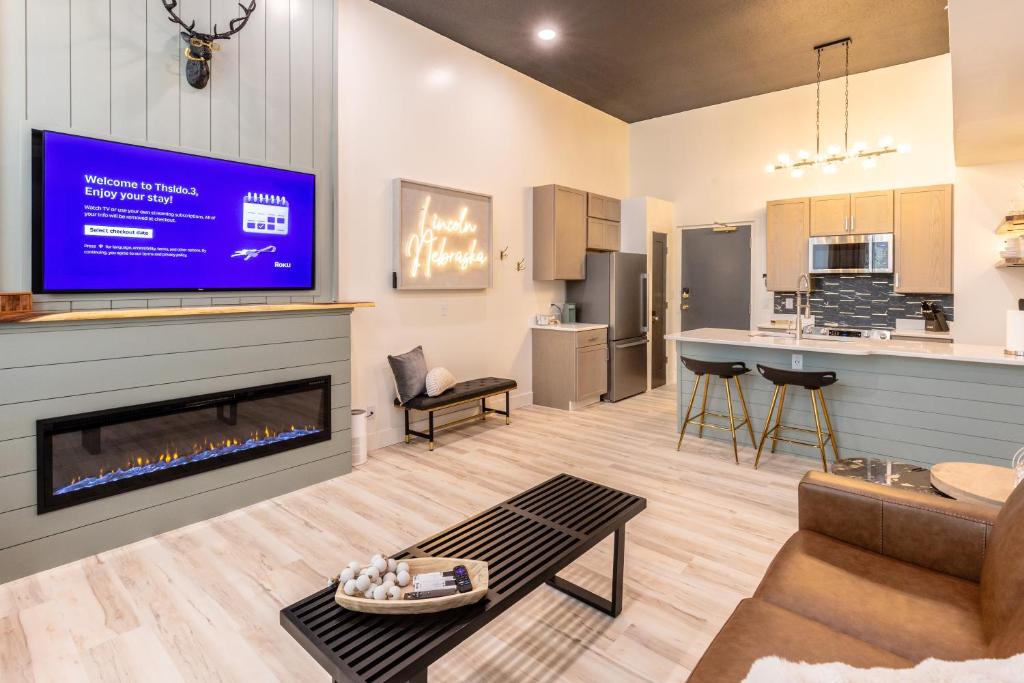 a living room with a fireplace and a kitchen at Boutique 1BR Condo - Walk to Memorial Stadium - Historic Hayward Place in Lincoln